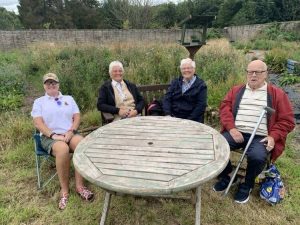 Veterans and family member sat round a table during our BBQ at Linburn