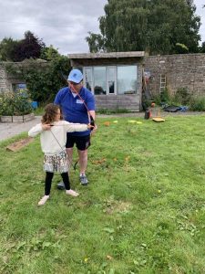 A veteran assist a child with archery during our BBQ at Linburn