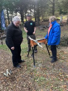 OP Cairngorms staff member demonstrating cutting of branches to two female veterans