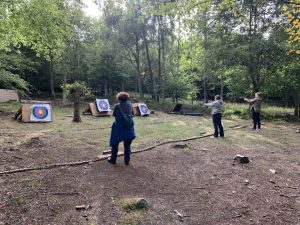 Female Veterans stand in line throwing axes at marks