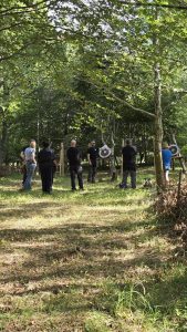 Veterans standing watching a demonstration on axe throwing during OP Cairngorms trip