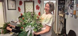 One female veteran showing off their wreath made during our Christmas wreath session