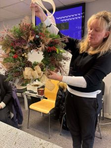One female veteran showing off their wreath made during our Christmas wreath session
