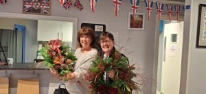 Two female veterans showing off their wreaths made during our Christmas wreath making session