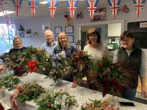 A group of female veterans showing off their Christmas wreaths made during our Christmas wreath making session