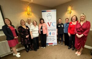 Group of female veterans standing in front of a sign