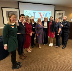 Group of female veterans standing in front of sign