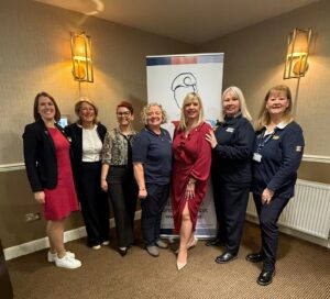 Group of female veterans standing in front of sign